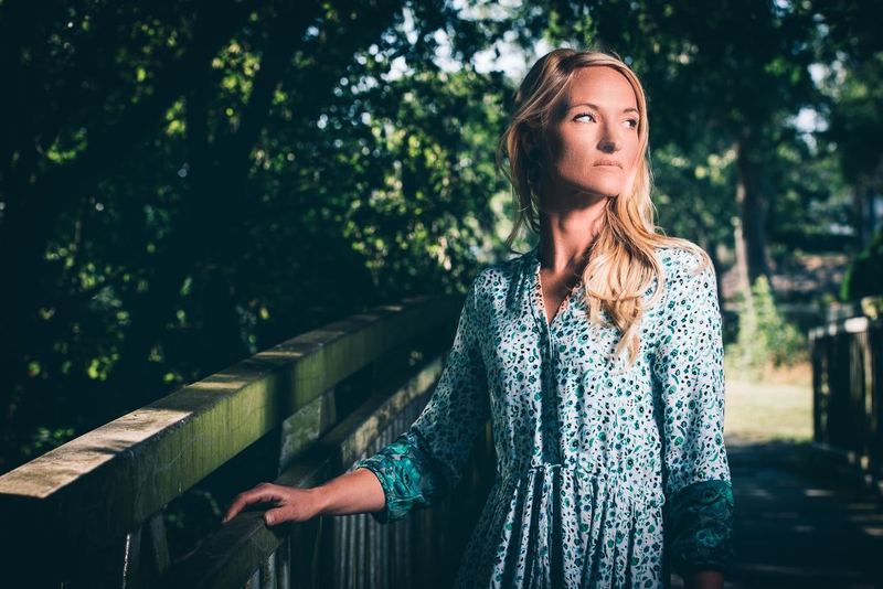 Blond lumineux aux reflets naturels, cheveux ondulés au vent