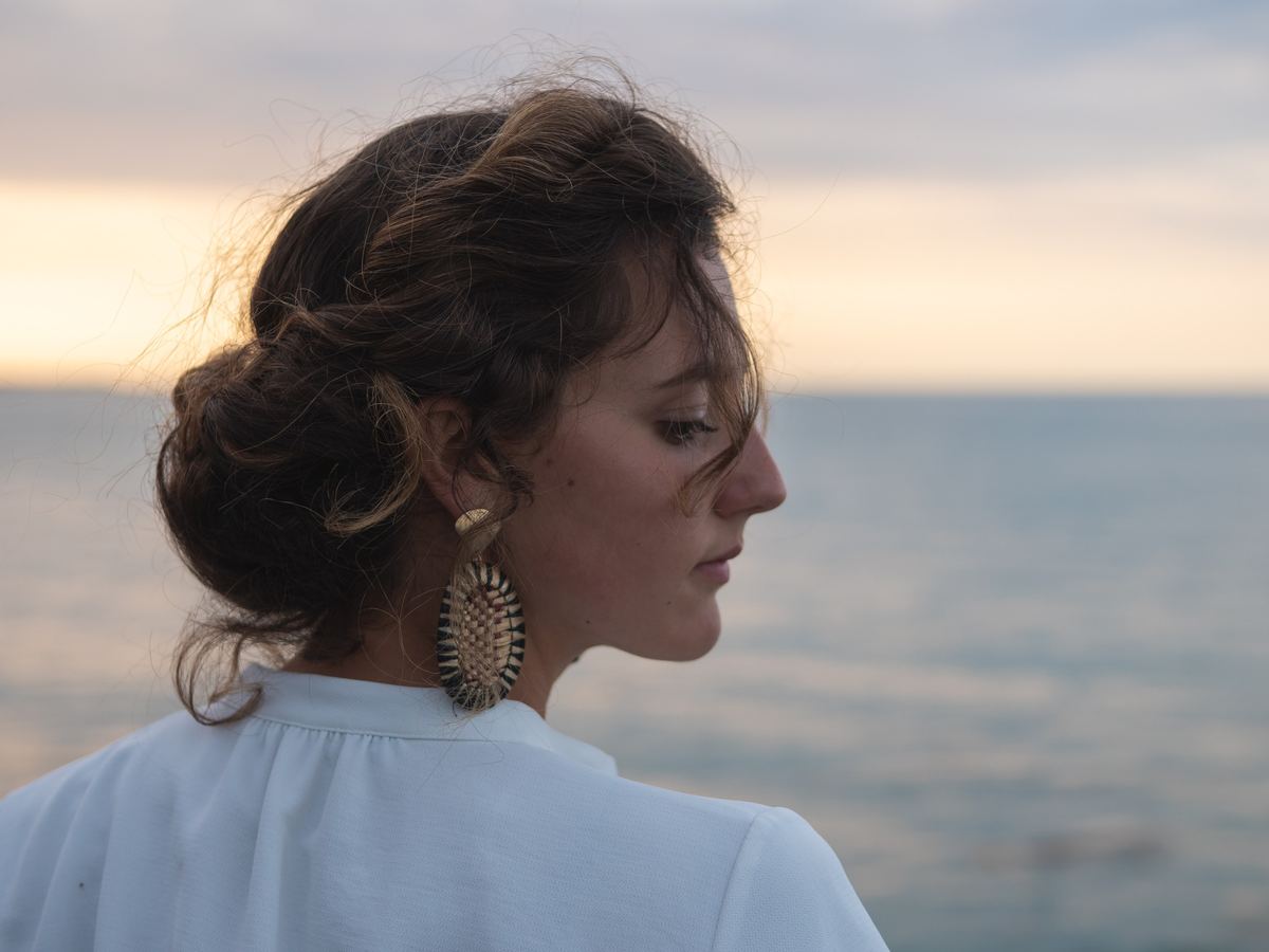 Chignon flou, mèches libres sur la nuque, au coucher du soleil